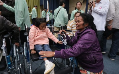 <p><strong>GRATEFUL.</strong> A Baguio City resident helps her physically-challenged child use the new wheelchair donated by the Filipino-Chinese Amity Club, Inc. in ceremonies in Baguio on Friday (June 15, 2018). The child was one of the 30 persons with disability, who were given free wheelchairs by the group that has been helping the Baguio City government through various programs. <em>(Photo by Liza T. Agoot)</em></p>